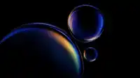 Stacked translucent spheres in cobalt with a bright rainbow band curving across the largest orb, ink-black void, Prismatic Orbs wallpaper