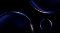 Three cobalt bubbles spread across an ink-black void with subtle amber and cyan dispersion on the rims, Prismatic Orbs wallpaper