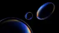 Cluster of blue prismatic spheres with a wide rainbow arc cutting across the bottom orb, deep black surround, Prismatic Orbs wallpaper