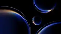 Four blue orbs of varying sizes drifting on a black void, amber prismatic flare on the leftmost sphere, Prismatic Orbs wallpaper